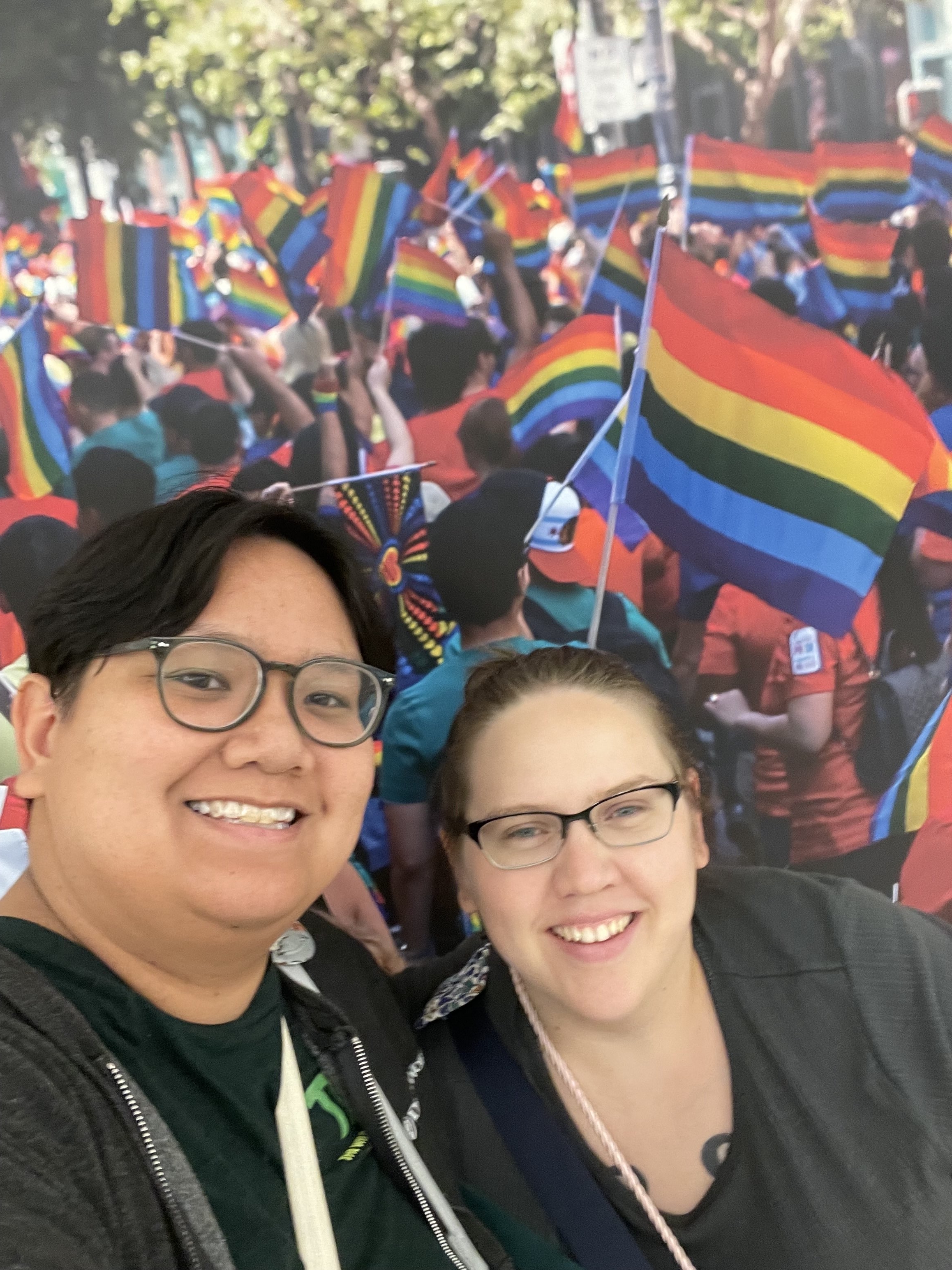 Photo and Shay and Elie in front of a pride parade mural in San Francisco!